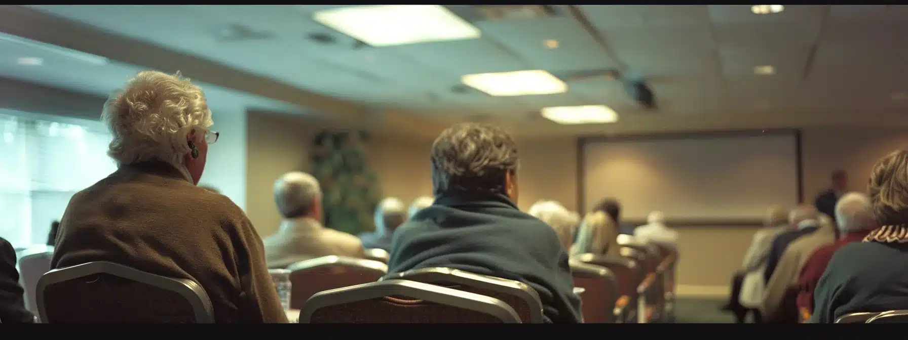 a focused caregiver training session in a well-equipped conference room, featuring attentive participants engaged in a lively discussion about resources for caring for individuals with dementia, illuminated by sharp overhead lighting that enhances the professional atmosphere.