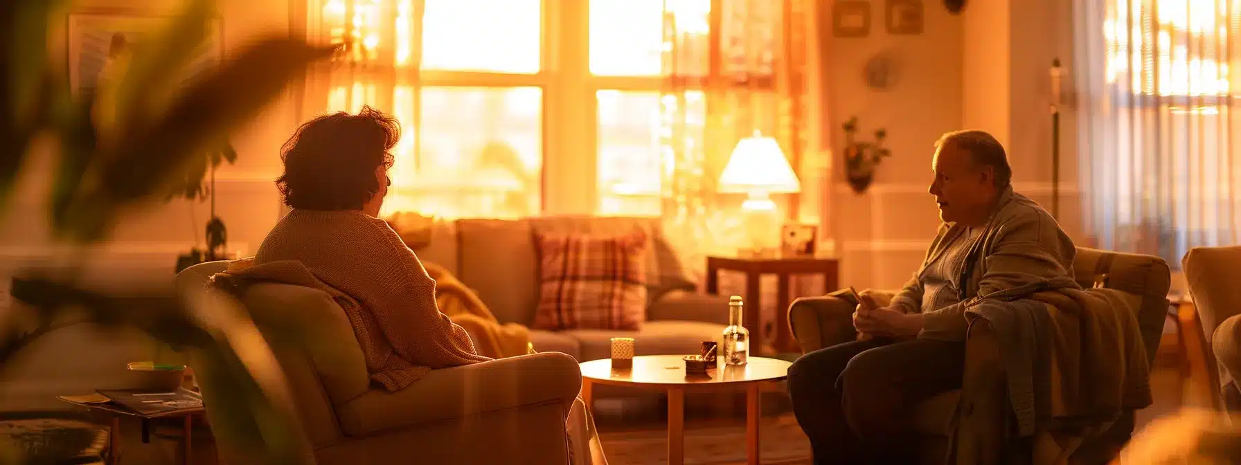 a serene and inviting common area of a memory care facility, featuring warm-toned furniture, engaged residents participating in a cognitive activity, and a caregiver attentively facilitating the session, all under soft, ambient lighting that enhances the comforting atmosphere.